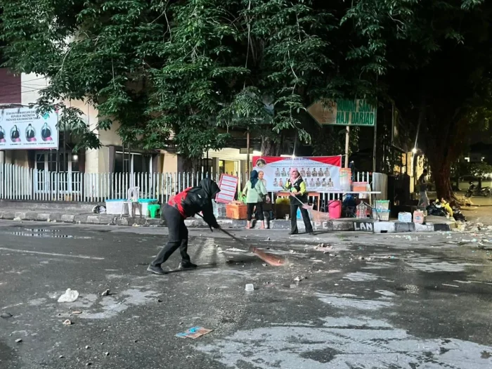 Petugas Dinas Lingkungan Hidup (DLH) Kota Samarinda membersihkan sisa-sisa sampah di area sekitar lokasi aksi unjuk rasa, pada Selasa malam (21/4/2026). Foto: BorneoFlash/Nur Ainunnisa