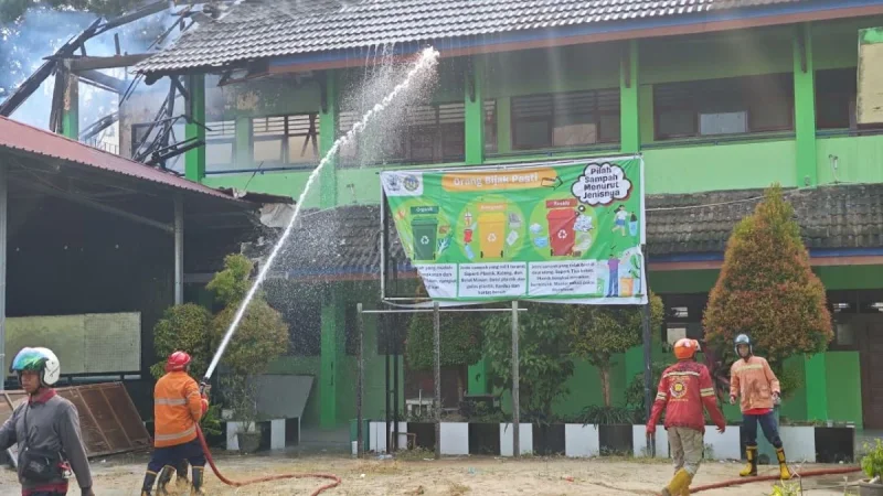 Petugas Disdamkarmat Kota Samarinda bersama relawan saat melakukan pemadaman kebakaran di SMPN 2 Samarinda. Foto: BorneoFlash/Nur Ainunnisa