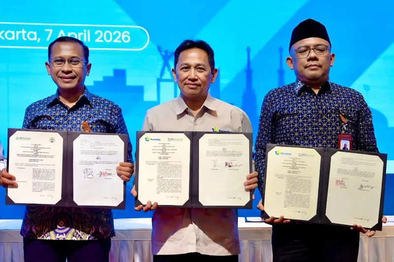 Sekretaris Kementerian Koperasi Ahmad Zabadi (tengah) dan Direktur Utama BPJS Kesehatan Prihati Pujowaskito (kiri) berfoto bersama usai penandatanganan nota kesepahaman (MoU) di Jakarta, Selasa (7/4/2026). FOTO: ANTARA/HO-Kemenkop.