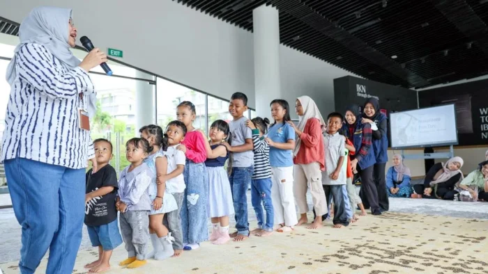 Ketua Panitia Pelayanan Kunjungan Masyarakat periode liburan, Myrna A. Safitri turun langsung mengajak anak-anak bermain dan membacakan dongeng pada Minggu (17/5/2026). Foto: HO/Humas Otorita IKN