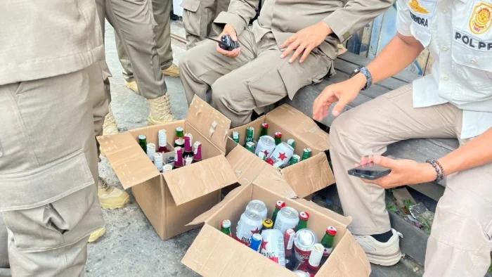 Petugas Satpol PP Samarinda menunjukkan puluhan botol minuman beralkohol yang diamankan dalam operasi penegakan Perda di dua lokasi berbeda. Foto: BorneoFlash/Nur Ainunnisa