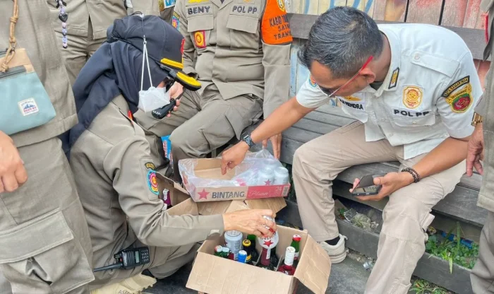 Petugas Satpol PP Samarinda menunjukkan puluhan botol minuman beralkohol yang diamankan dalam operasi penegakan Perda di dua lokasi berbeda. Foto: BorneoFlash/Nur Ainunnisa