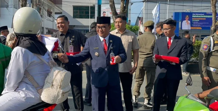 Wakil Wali Kota Balikpapan H. Bagus Susetyo saat membagikan bendera merah putih kepada masyarakat di depan Balai Kota Balikpapan, pada Senin (1/6/2026). Foto: BorneoFlash/Niken Sulastri