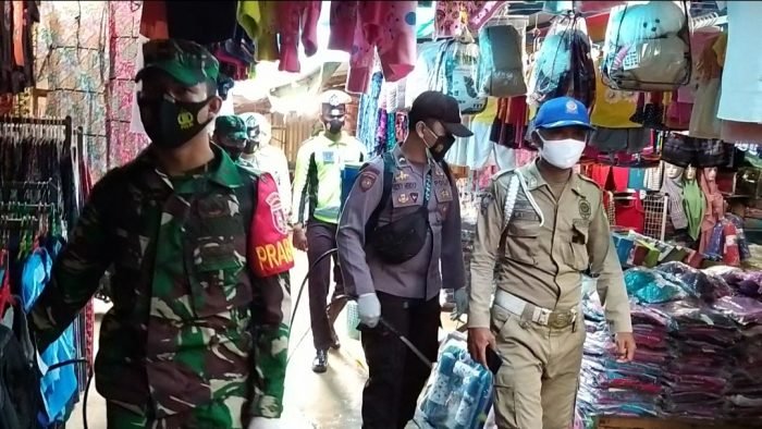 Penyemprotan cairan desinfektan oleh aparat gabungan TNI –Polri di Pasar Jaras Kabupaten Kutai Barat.