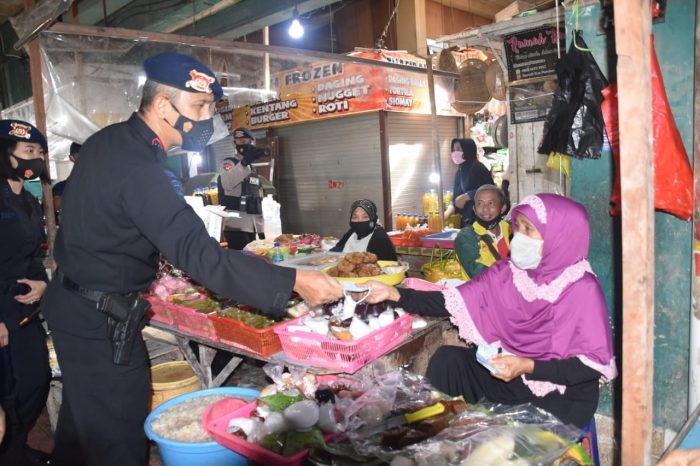 Dansat Brimob Polda Kaltim Bagikan Ratusan Masker ke Pedagang pasar klandasan. Jumat (19/2/2021).