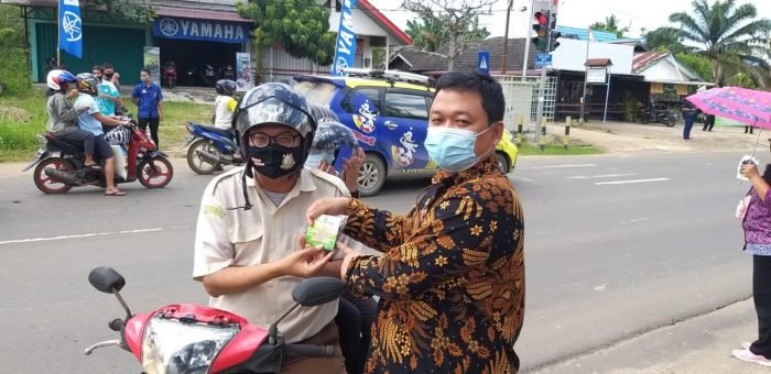 Ketua Pengadilan Negeri (PN) kelas II Kabupaten Kutai Barat, Jemmy Tanjung Utama, SH.,MH membagikan masker kepada pengguna jalan raya. Foto : BorneoFlash.com/ Lilis Suryani.