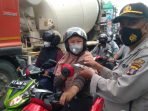 Kanit Binmas Polsek Balikpapan Utara Iptu Suliyono membagikan masker di Simpang Lima Muara Rapak pada Kamis (25/2/2021) lalu.Foto : BorneoFlash.com/ Muhammad Eko.