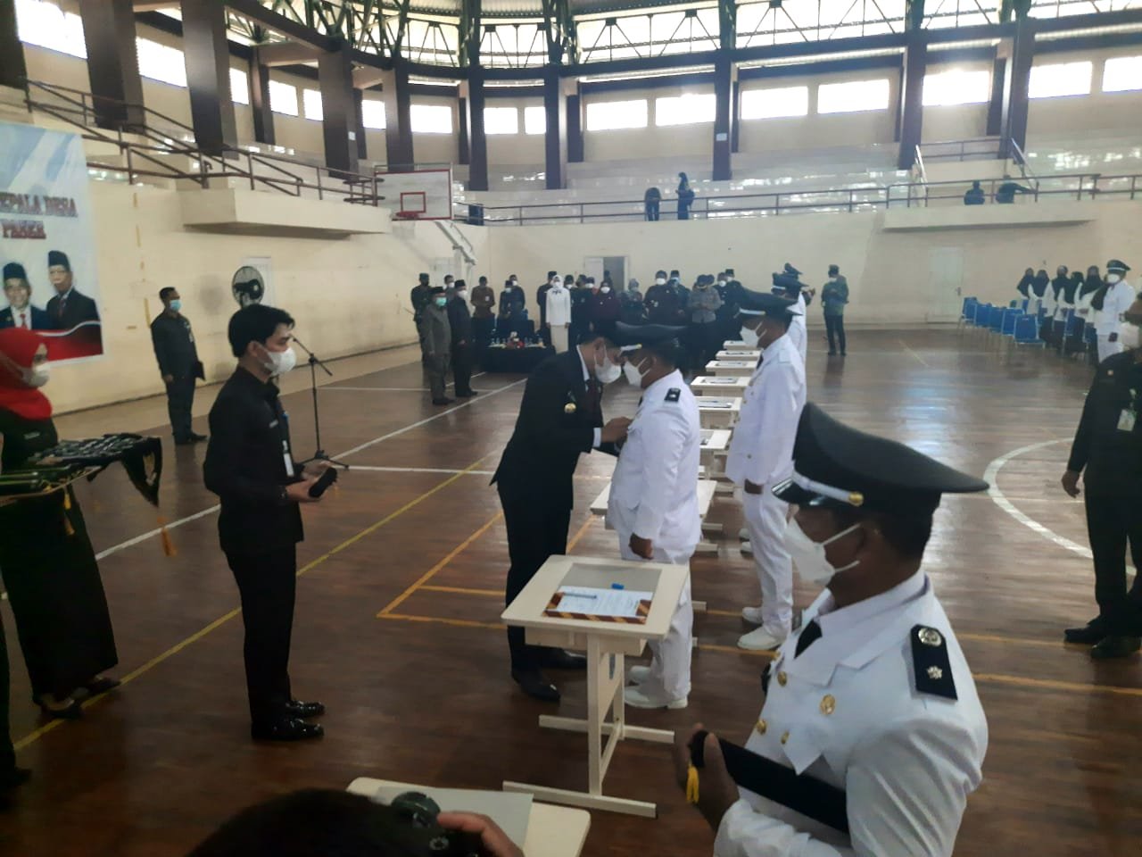 Bupati Paser dr. Fahmi Fadli saat melakukan penyematan pangkat dan tanda jabatan kepada salah satu Kepala Desa dari 52 Kades yang dilantik yang berlangsung di Gedung Olahraga (GOR) Desa Tapis, Kecamatan Tanah Grogot, Kabupaten Paser, Kalimantan Timur. Kamis (24/6/2021). Foto : BorneoFlash.com/Fitriani.