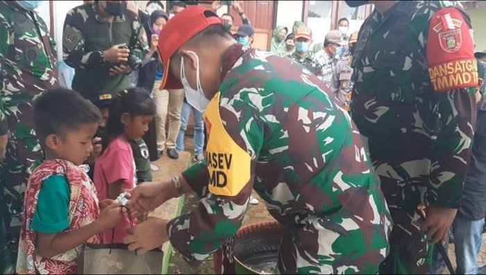 Tim Asistensi Penanggung jawab Operasional (PJO) Irsus Itjenad Brigjen TNI Irham Waroihan, saat memberikan bingkisan kepada salah seorang anak usai mengikuti sunatan massal, di Kantor Desa Kerang Dayo, Kecamatan Batu Engau, Kabupaten Paser, Kalimantan Timur. Kamis (8/7/2021). Foto : BorneoFlash.com/Fitriani.