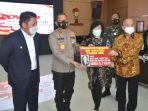 Keluarga alm Akidi Tio Melalui dokter keluarga mereka Prof dr Hardi Darmawan, Serahkan bantuan covid-19 sebesar Rp 2 T di Mapolda Sumsel, Senin (26/7/2021). Foto : HO.