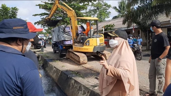 Pengerukan sampah drainase menggunakan excavator mini yang dilakukan Pemerintah Kabupaten Paser bersama masyarakat saat kegiatan bersih-bersih lingkungan yang juga di dihadiri Wakil Bupati (Wabup) Paser Hj. Syarifah Masitah Assegaf pada Minggu (8/8/2021). Foto : BorneoFlash.com/Fitriani.
