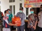 Kepala Dinas Sosial Kubar, Ampeng menyerahkan bantuan paket sembako secara simbolis kepada warga di Kampung Tanjung Isuy yang sedang menjalani Isoman akibat covid-19. Foto ; BorneoFlash.com/Lilis Suryani.