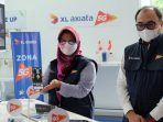 Presiden Direktur & CEO XL Axiata, Dian Siswarini (kiri) bersama dengan Direktur & Chief Technology Officer XL Axiata, I Gede Darmayusa (kanan) mencoba demo layanan 5G yang tersedia di XL Center, XL Axiata Tower, Jakarta, Rabu (18/8/2021). Foto : HO.