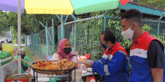Pedagang asongan di Lapangan Merdeka, mendapat kupon yang bisa ditukarkan bahan makanan dari para pekerja muda Pertamina. Foto : HO.
