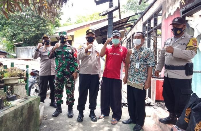 Kapolsek Balikpapan Barat Kompol Totok Eko Darminto di dampingi Ketua RT 50 Kelurahan Margo Mulyo, Ikrom Sonhadji nampak menyerahkan bantuan paket sembako secara langsung kepada korban kebakaran Kamis (14/10/2021). Foto : BorneoFlash.com/Muhammad Eko.