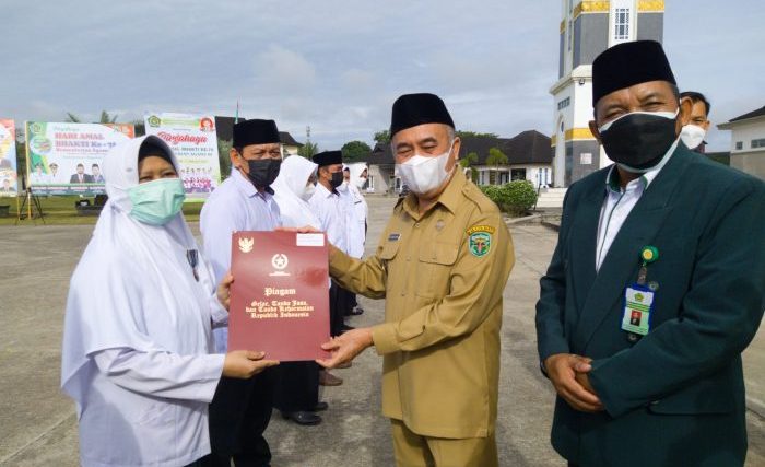 Wakil Bupati Kutai Barat, H. Edyanto Arkan memberikan tanda penganugerahan Satyalancana Karya Satya kepada 17 aparatur sipil negara (ASN) Kemenag Kutai Barat. Foto : BorneoFlash.com/Lilis Suryani.