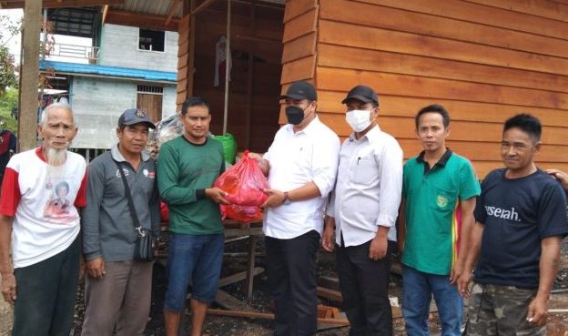Ketua GAMKI Kubar, FX Sumardi dan Ketua STB Kubar, Roni Patinasrani saat menyalurkan bantuan pada Petinggi Kampung Muara Batuq untuk diserahkan kepada para korban musibah kebakaran. Foto : BorneoFlash.com/Lilis Suryani.