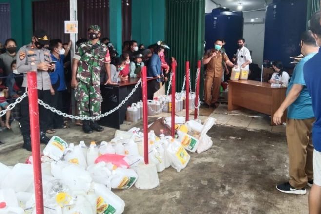 Masyarakat di Kubar harus rela mengantre minyak goreng curah karena harga minyak goreng kemasan premium masih terlampau tinggi. Foto: BorneoFlash.com/Lilis Suryani.