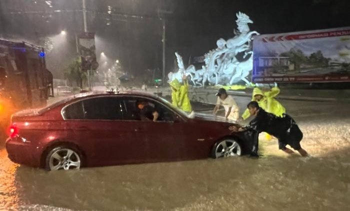 Pammat Dit Samapta Polda Kaltim Membantu arus lalulintas yang sempat terhambat akibat Banjir yang menggenangi kawasan Jl. MT Haryono Balikpapan pada Selasa malam (14/9/2022). Foto: HO/Humas Polda Kaltim.