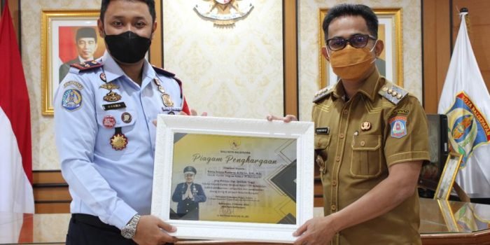 Wali Kota Balikpapan H. Rahmad Mas’ud menyerahkan penghargaan kepada Kepala Kantor Imigrasi Kelas I TPI Balikpapan, Rakha Sukma Purnama. Foto: HO/Kanim Balikpapan.