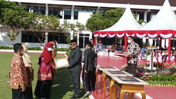 Ketua DPRD H Abdulloh saat menyerahkan penghargaan pada peringatan upacara HKN ke 58, di Halaman Kantor Wali Kota Balikpapan pada hari Sabtu (12/11/2022). Foto: BorneoFlash.com/Niken Sulastri.