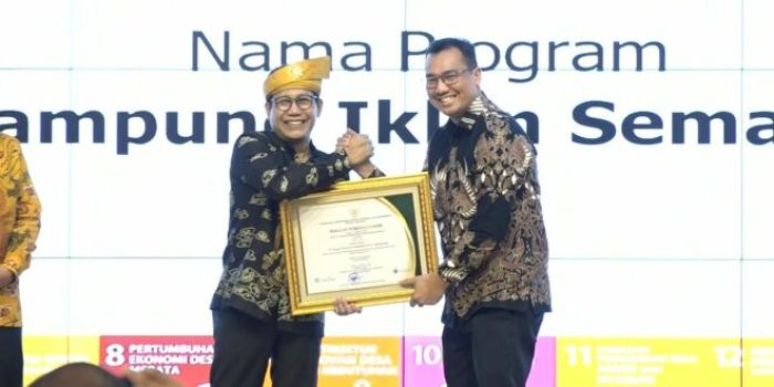 Manager Communications, Relations & CSR PT KPI Unit Balikpapan Ely Chandra Peranginangin  (kanan) menerima penghargaan yang diserahkan langsung oleh Menteri Desa PDTT Abdul Halim Iskandar, Jumat (3/1/2023). Foto: HO/PT KPI Unit Balikpapan.