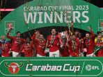 Pemain Manchester United merayakan kemenangan dengan mengangkat trofi Carabao Cup 2023 setelah mengalahkan Newcastle United di Wembley Stadium, Minggu (26/2/2023) waktu setempat. Foto: AFP/Glyn Kirk.