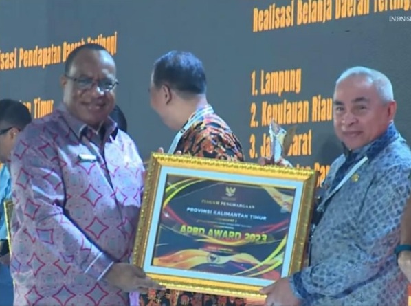Gubernur Kaltim, Isran Noor, saat menerima penghargaan dari Wamen John Wempi Wetipo untuk Provinsi Kaltim sebagai Provinsi Terbaik Realisasi Pendapatan Daerah Tertinggi Tahun 2022 dalam ajang APBD Award 2023, Kamis (16/3/2023). Foto: BorneoFlash.com/Ist.