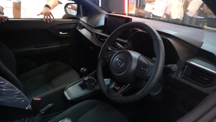 Di dalam kabin, All-New Agya GR Sport tersemat beberapa sentuhan signature GR Sport, seperti dark silver ornament color pada kisi AC, GR Sport logo dan red stitch pada bangku depan dan bagian bawah kemudi sudah berbahan kulit sintetis, floor mat, serta leather shift knob. Foto: BorneoFlash.com/Ardian.