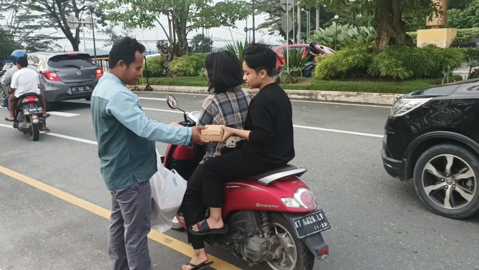 KSTB berbagi takjil kepada pengendara yang melintasi pintu masuk Perumahan Grand City di kilometer 7 Jalan Soekarno Hatta, pada hari Jumat (14/4/2023) sore. Foto: BorneoFlash.com/Niken Sulastri.