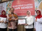 Kepala Dinas Kesehatan Kota Balikpapan, dr Andi Sri Juliarty saat menyerahkan sertifikat kepada Saptono Nugroho yang mendapatkan penghargaan Satyalancana Kebaktian Sosial, karena telah melakukan donor darah sebanyak 100 kali. Foto: BorneoFlash.com/Niken Sulastri.