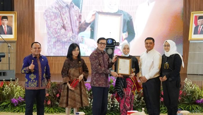 Menteri Hukum dan Hak Asasi Manusia RI (Menkumham RI), Yasonna H. Laoly, memberikan apresiasi berupa pemberian piagam serta surat pencatatan hak cipta atas dua lagu Putri yang berjudul 'Loneliness' dan ‘Permata Indah Dunia’, di Graha Pengayoman Kementerian Hukum dan HAM, Jakarta Selatan, pada Selasa, (20/6/2023). Foto: BorneoFlash.com/Ist.