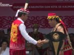 Kepala Adat Besar Kabupaten Kutai Barat, Manaar Dimansyah saat Memberikan Gelar adat bangsawan suku Dayak Benuaq kepada Presiden Jokowi "Ajiq Tatau Narakng Bulau, Penimakng Sookng Mantiq, Penerajuq Bawe Ayakng". Foto: HO/Humas Pemkab Kubar.