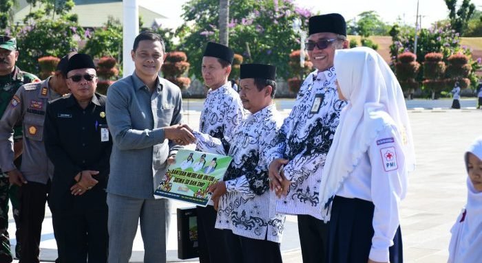 Ketua DPRD Kabupaten Paser, Hendra Wahyudi, saat menyerahkan bantuan secara simbolis pada upacara Peringatan Hari Guru Nasional (HGN) ke-78 di Halaman Kantor Bupati Paser, Senin (27/11/2023). Foto: BorneoFlash.com/Joe.