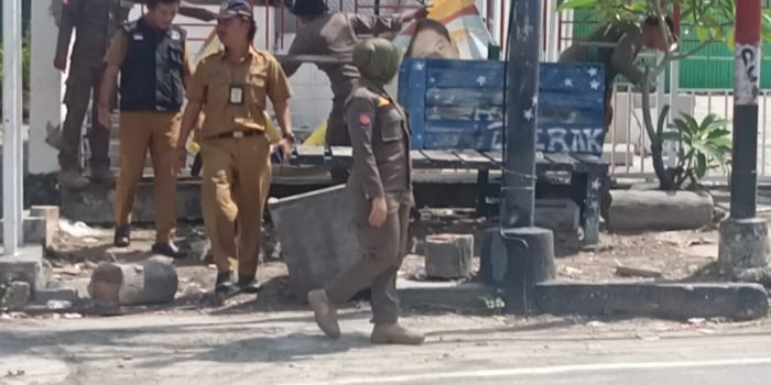 Tim dari Kecamatan Balikpapan Kota bersama Satuan Polisi Pamong Praja saat menertibkan spanduk yang berada di pagar salah satu bangunan kantor, di sekitar pelabuhan pada hari Senin (6/11/ 2023). Foto: BorneoFlash.com/Niken Sulastri.