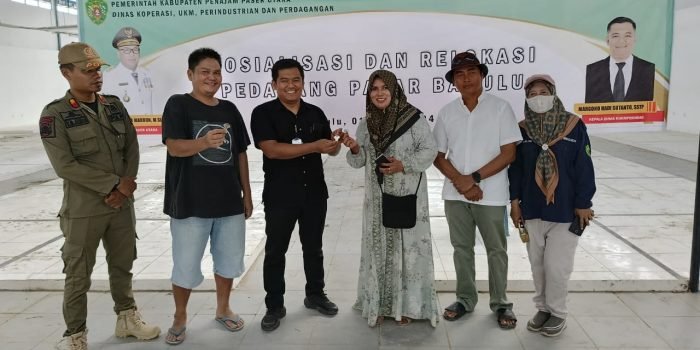 Kepala Dinas KUKMPerindag Penajam Paser Utara (PPU) Margono Hadi Susanto saat menyerahkan undian kepada seorang pedagang di Pasar Babulu. Foto: IST/DiskominfoPPU