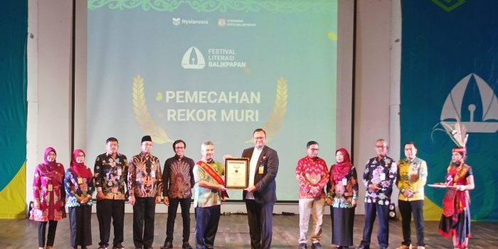 Direktur Marketing MURI, Awan Rahargo menyerahkan penghargaan MURI kepada Staf Ahli Bidang Sosial, Kesejahteraan dan Pengembangan SDM Setda Kota Balikpapan, Adamin Siregar, mewakili Wali Kota Balikpapan H Rahmad Mas'ud, pada Puncak Festival Literasi Balikpapan Tahun 2023, di Gedung Kesenian Balikpapan, pada hari Kamis (18/4/2024). Foto: BorneoFlash/Niken Sulastri