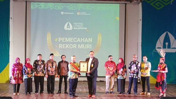 Direktur Marketing MURI, Awan Rahargo menyerahkan penghargaan MURI kepada Staf Ahli Bidang Sosial, Kesejahteraan dan Pengembangan SDM Setda Kota Balikpapan, Adamin Siregar, mewakili Wali Kota Balikpapan H Rahmad Mas'ud, pada Puncak Festival Literasi Balikpapan Tahun 2023, di Gedung Kesenian Balikpapan, pada hari Kamis (18/4/2024). Foto: BorneoFlash/Niken Sulastri