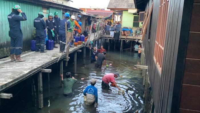 Dinas Lingkungan Hidup Kota Balikpapan dan warga ikut membantu membersihkan Tumpahan limbah minyak di area pemukiman atas air di Kelurahan Margasari, Kecamatan Balikpapan Barat, pada hari Jumat (24/5/2024).  Foto: BorneoFlash/IST