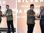 Menteri Desa PDTT Abdul Halim Iskandar menyerahkan penghargaan kepada GM Zona 9 Subholding Upstream Pertamina Regional 3, Andre Wijanarko dan Head of Communication Relations & CID Zona 9 Elis Fauziyah di Hotel The Westin Jakarta pada Selasa (7/5/2024). Foto: HO/PT PHI