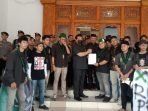 Ketua DPRD Kota Balikpapan Abdulloh bersama Wakil Ketua I DPRD Balikpapan Budiono menemui para mahasiswa HMI Cabang Balikpapan, saat melakukan unjuk rasa di Kantor DPRD Balikpapan, pada hari Kamis (13/6/2024). Foto: BorneoFlash/Niken Sulastri