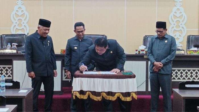 Ketua DPRD Kota Balikpapan H. Abdulloh saat melakukan penandatangan berita acara persetujuan bersama dalam rapat paripurna DPRD Balikpapan, pada hari Selasa (2/7/2024). Foto: BorneoFlash/Niken Sulastri