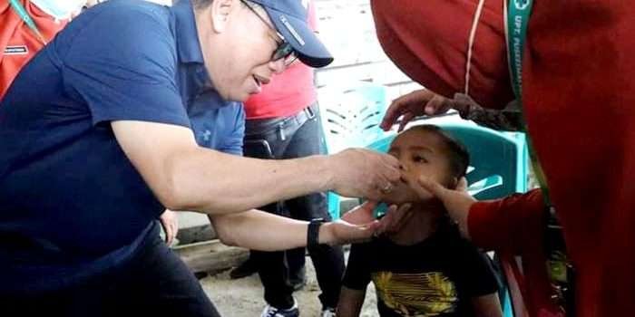 Pj Bupati PPU Makmur Marbun meneteskan vaksin kepada seorang anak dalam pelaksanaan Pekan Imunisasi Nasional (PIN) Polio , di Kantor Kelurahan Petung, Kecamatan Penajam, Sabtu (27/7/2024). Foto: IST/DiskominfoPPU