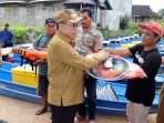 Pj Bupati PPU Makmur Marbun menyerahkan bantuan kapal dan alat tangkap ikan kepada nelayan di Desa Babulu Laut, Kecamatan Babulu, Kabupaten PPU, Kalimantan Timur, Selasa (2/7/2024). Foto: IST/DiskominfoPPU