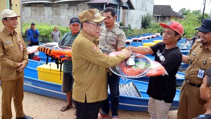 Pj Bupati PPU Makmur Marbun menyerahkan bantuan kapal dan alat tangkap ikan kepada nelayan di Desa Babulu Laut, Kecamatan Babulu, Kabupaten PPU, Kalimantan Timur, Selasa (2/7/2024). Foto: IST/DiskominfoPPU
