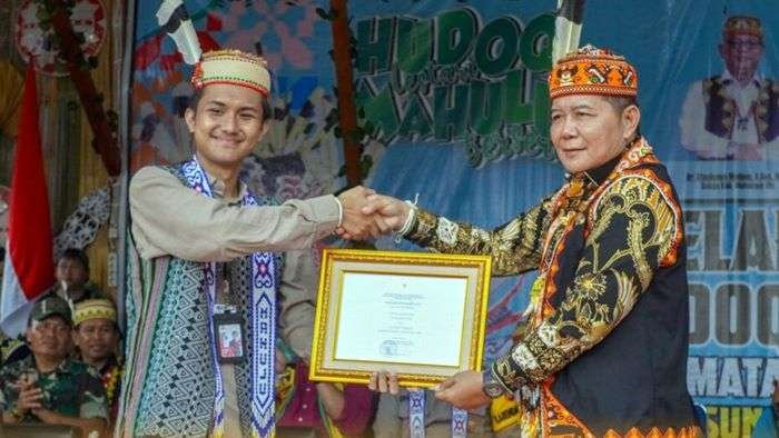 Bupati Mahulu, Dr. Bonifasius Belawan Geh menerima penghargaan atas terpilihnya Festival Hudoq Pekayang sebagai salah satu dari 110 event terbaik dalam Karisma Event Nusantara (KEN) 2024 yang diberikan langsung oleh perwakilan Kemenparekraf, Wilda. Foto: HO/Prokopim Mahulu