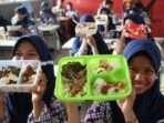 Sejumlah siswa menunjukkan makanan gratis saat simulasi program makan siang gratis di SMP Negeri 2 Curug, Kabupaten Tangerang, Banten. Foto: BorneoFlash.com/Ist