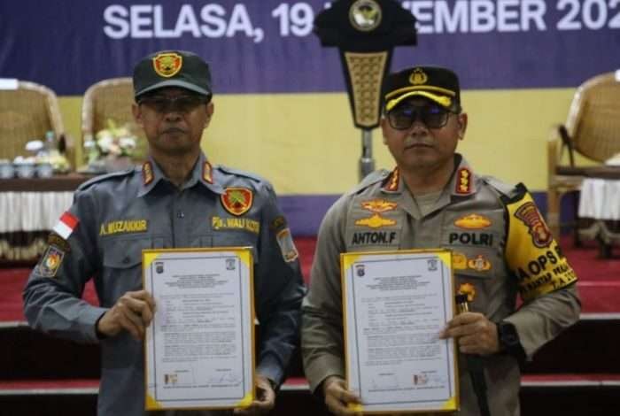 Pjs Wali Kota Balikpapan, Ahmad Muzakkir menyerahkan 1.992 personel Linmas kepada Kapolresta Balikpapan, Kombes Pol Anton Firmanto, di Gedung Balikpapan Sport and Convention Center (BSCC)/Dome, Balikpapan, pada Selasa (19/11/2024). Foto: BorneoFlash/Niken Sulastri