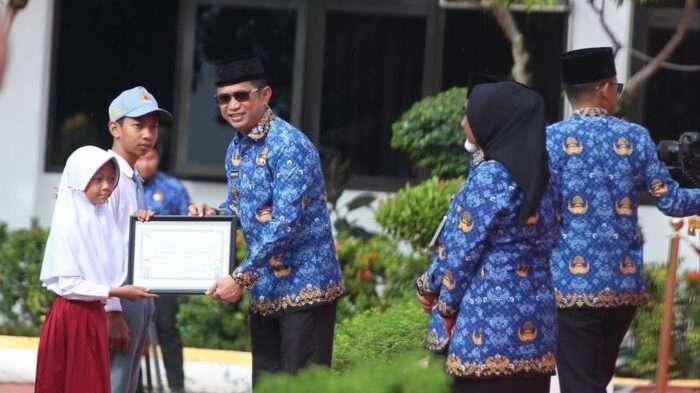 Wali Kota Balikpapan Rahmad Mas’ud saat menyerahkan beasiswa kepada 7 anak ASN sebagai bentuk dukungan terhadap pendidikan generasi penerus, pada upacara peringatan HUT ke-53 KORPRI berlangsung di halaman Balai Kota Balikpapan, pada Jumat (29/11/2024). Foto: BorneoFlash/Niken Sulastri