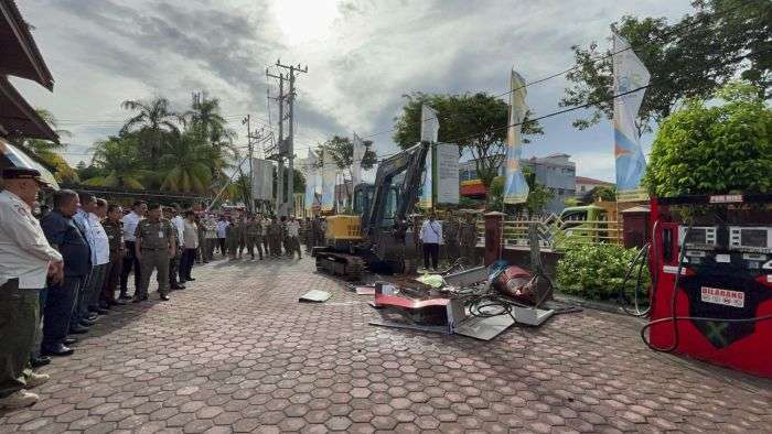 Pemusnahan terhadap 1.089 botol dan kaleng minuman keras serta 37 dispenser pom mini hasil operasi penertiban selama tahun 2024, digelar di halaman Kantor Satpol PP Balikpapan, pada Rabu (26/2/2025). Foto: BorneoFlash/Niken Sulastri